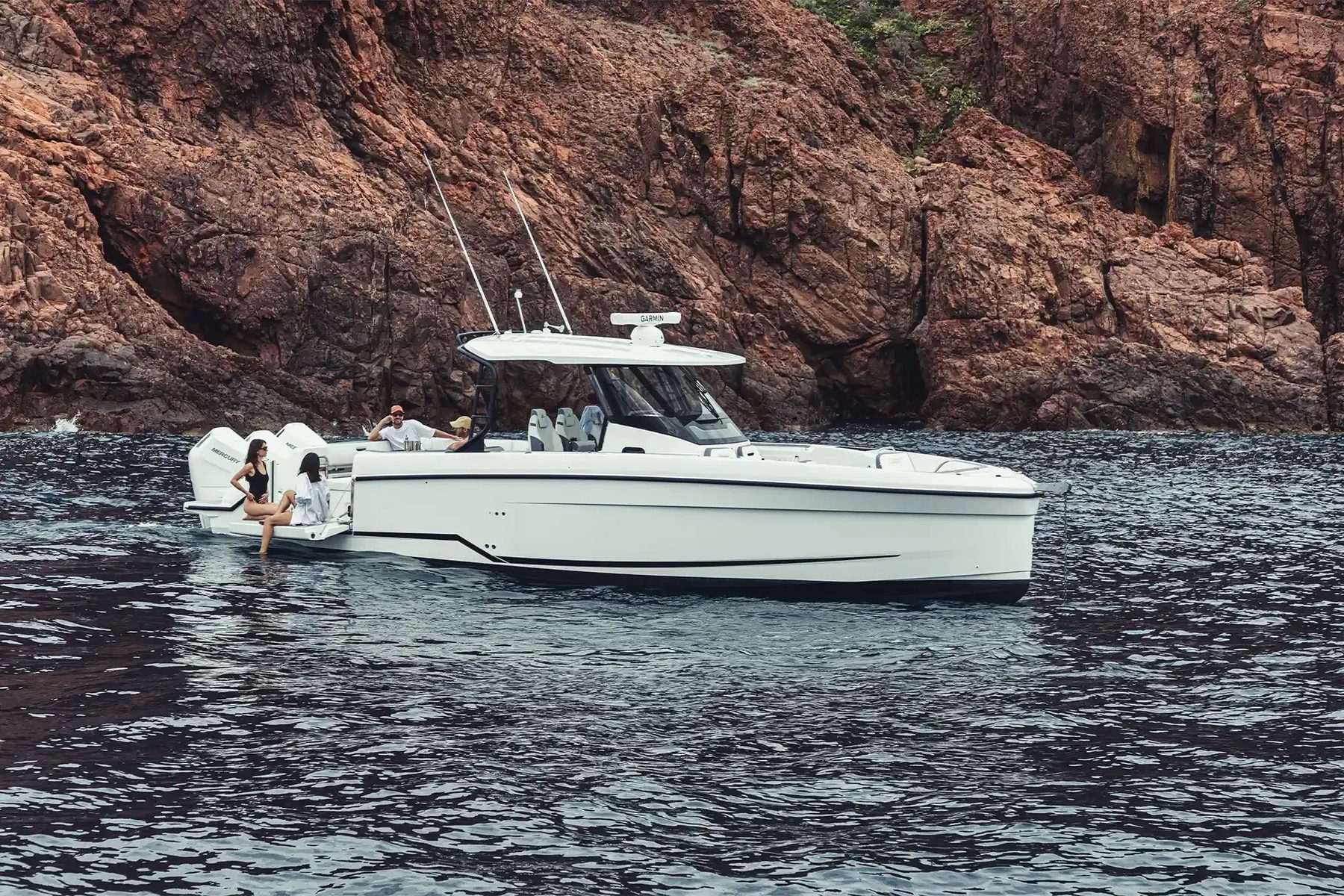 Wellcraft 38 T-Top: катер для дня, который проходит у воды Wellcraft 38 T-Top: профиль на стоянке у скал